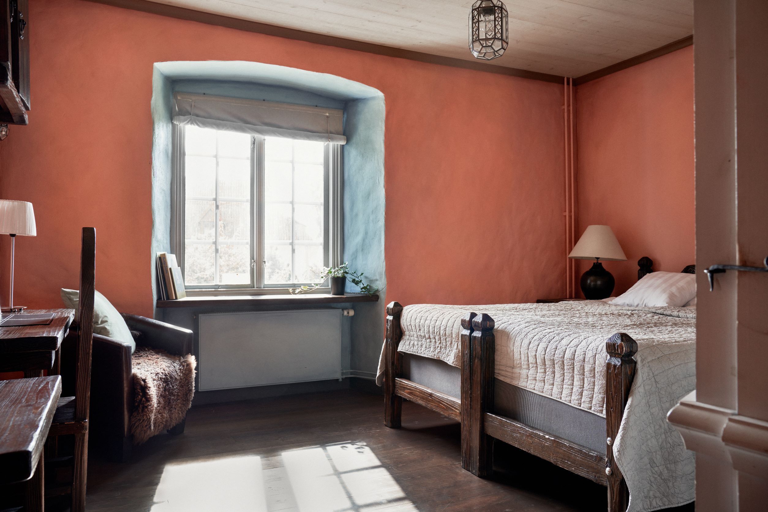 Una camera da letto con finestra, un letto, una sedia e una scrivania.