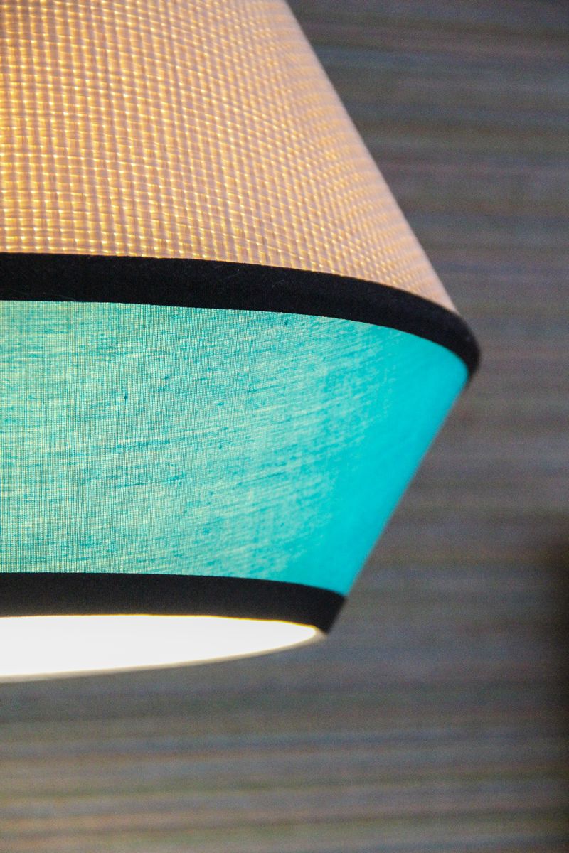 A close-up of a lamp with a textured fabric shade.