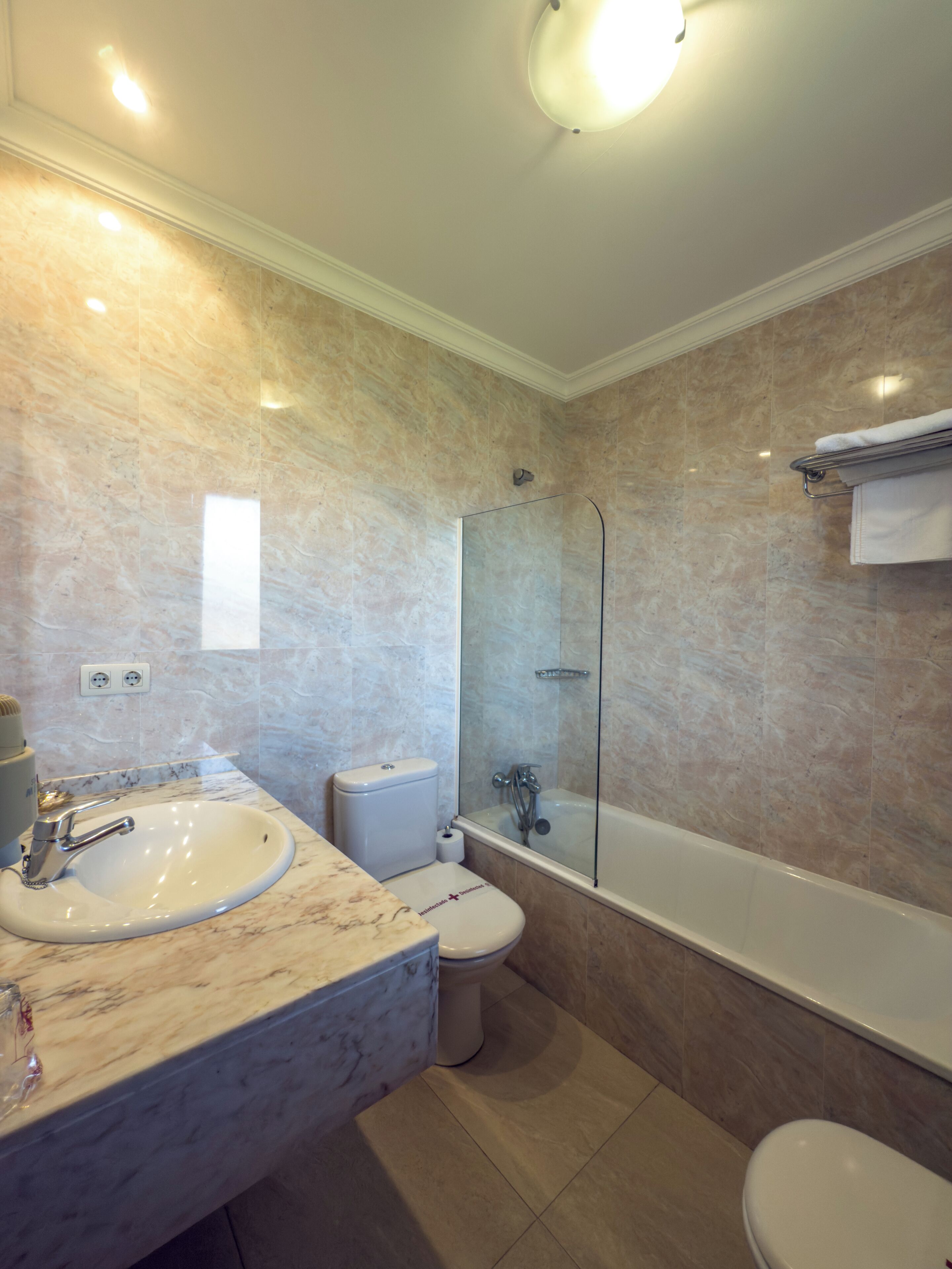 Un baño moderno con lavamanos, inodoro y bañera de mármol.