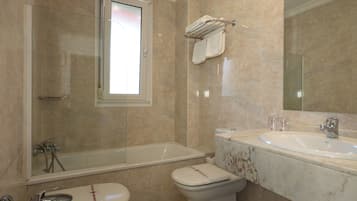Et moderne badeværelse med badekar, toilet og håndvask.