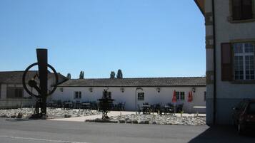 A building with outdoor seating and a large metal sculpture.