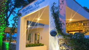 A building with a sign reading "Butikhan Beach Otel & Restaurant" and a sign for "By Liana Hotels". - Butikhan Otel (Bodrum)