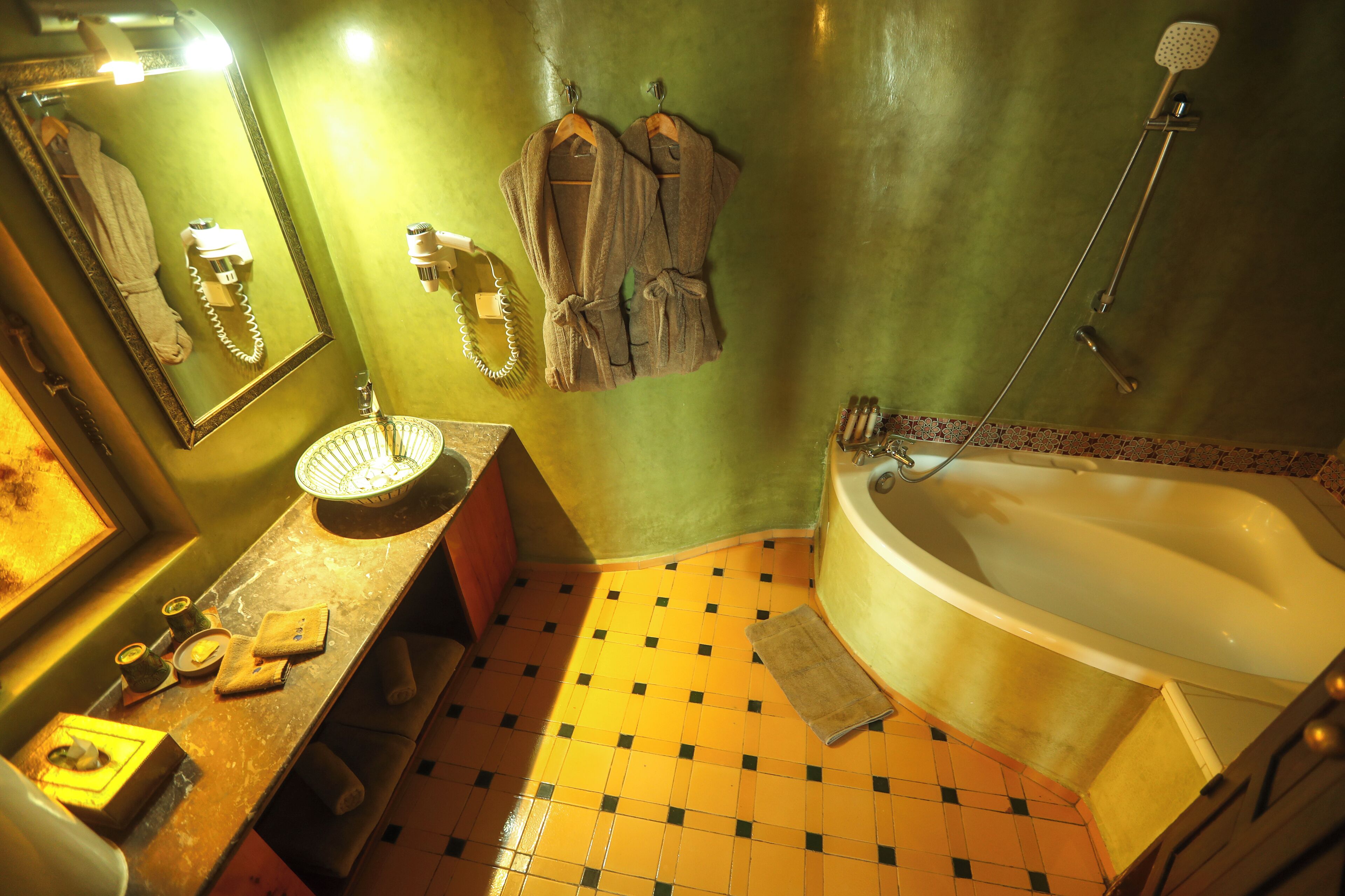 Une salle de bain avec une grande baignoire, un lavabo avec un miroir et un porte-serviettes.