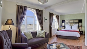 Una habitación de hotel con cama, sofá y vista al mar.