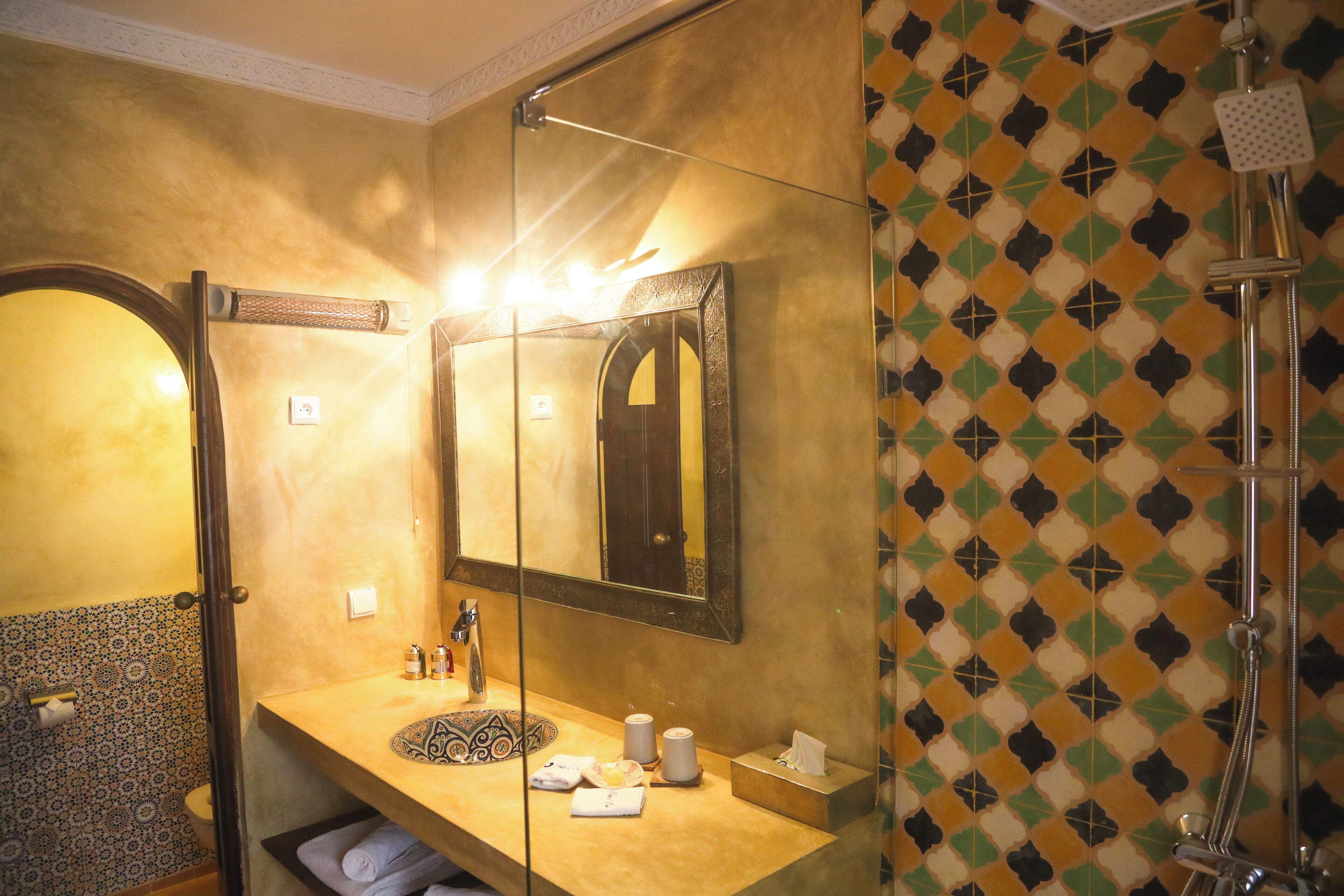 A bathroom with a sink, mirror, and shower.