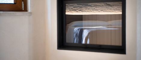 Cuadro con una cama y un fondo de pared de piedra, colgado en la pared.