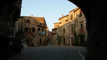 Un edificio antiguo de piedra con un patio central, un arco de entrada y arquitectura tradicional.