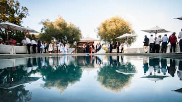 Una piscina al aire libre de temporada, sombrillas