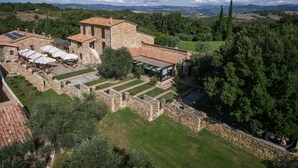 Vista aérea de un edificio de piedra con mesas al aire libre y un jardín.