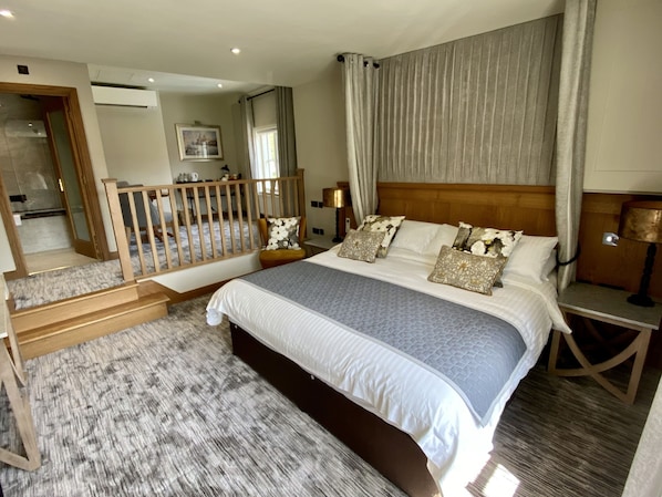 A spacious bedroom with a large bed, a wooden headboard, and a view of a balcony. - The Star Inn 1744 (Leicester)