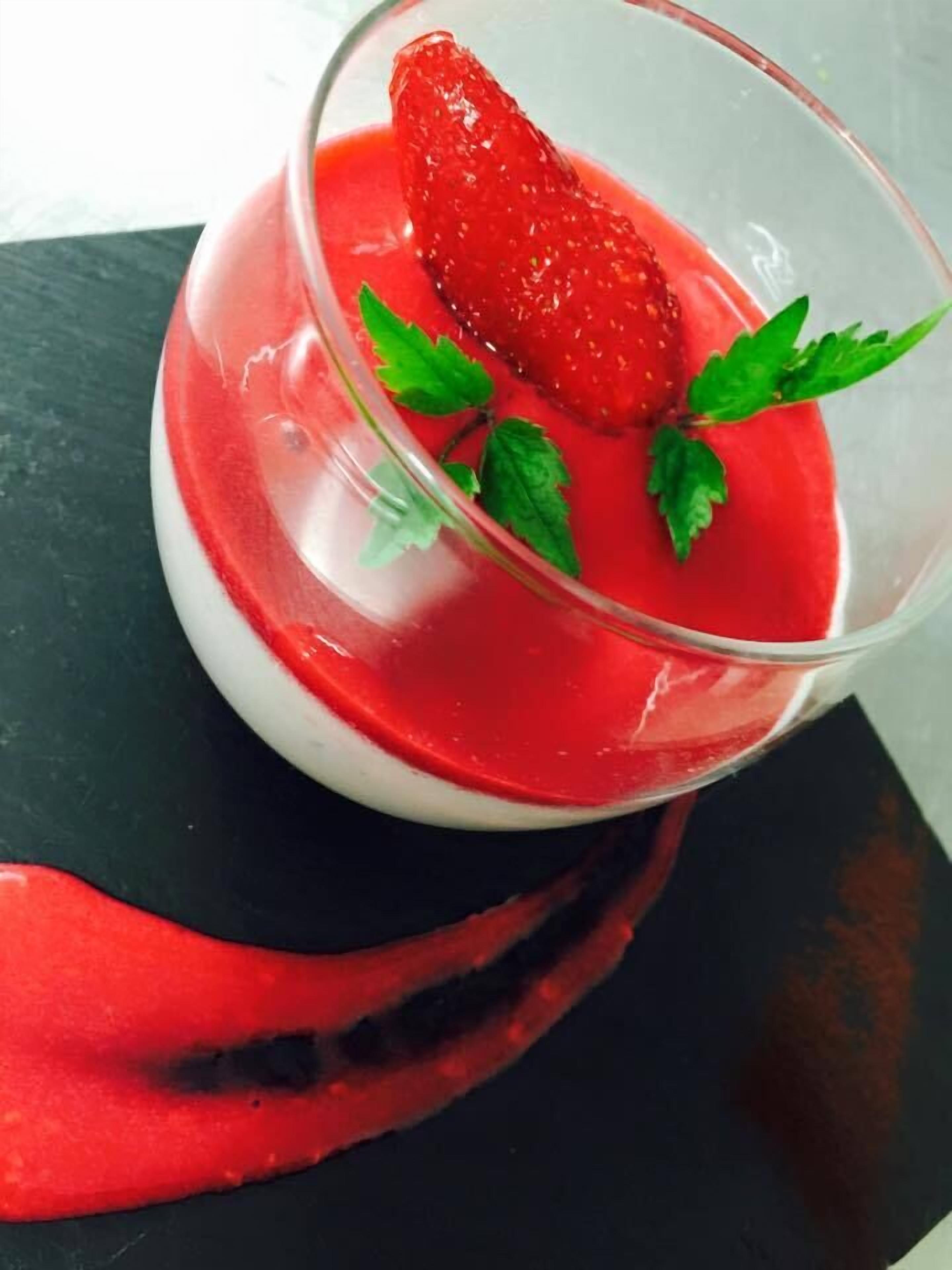 Ein Dessert mit Erdbeer- und Minzdruck in einem Glas.