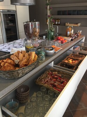A buffet with various food items, including pastries, fruits, and condiments. - Auberge Les Galets Hotel Restaurant (Peyruis)