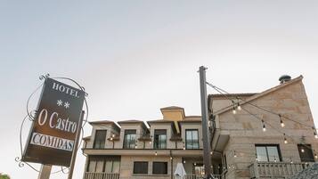 Un hôtel avec une enseigne indiquant « HÔTEL O Castro, RESTAURATION ».