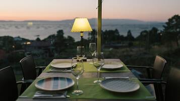 Mesa para dos con vista al mar y montañas al fondo.