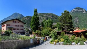 A building with a red roof and a sign indicating a parking area. - Rêves Gourmands (Vernayaz)