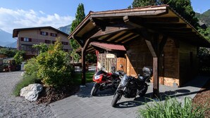 A wooden building with a covered entrance and two motorcycles parked in front. - Rêves Gourmands (Vernayaz)