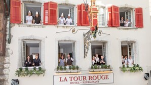 A hotel with multiple windows, some open, and a sign reading "LA TOUR ROUGE HOTEL RESTAURANT". - Hotel Roter Turm (Solothurn)