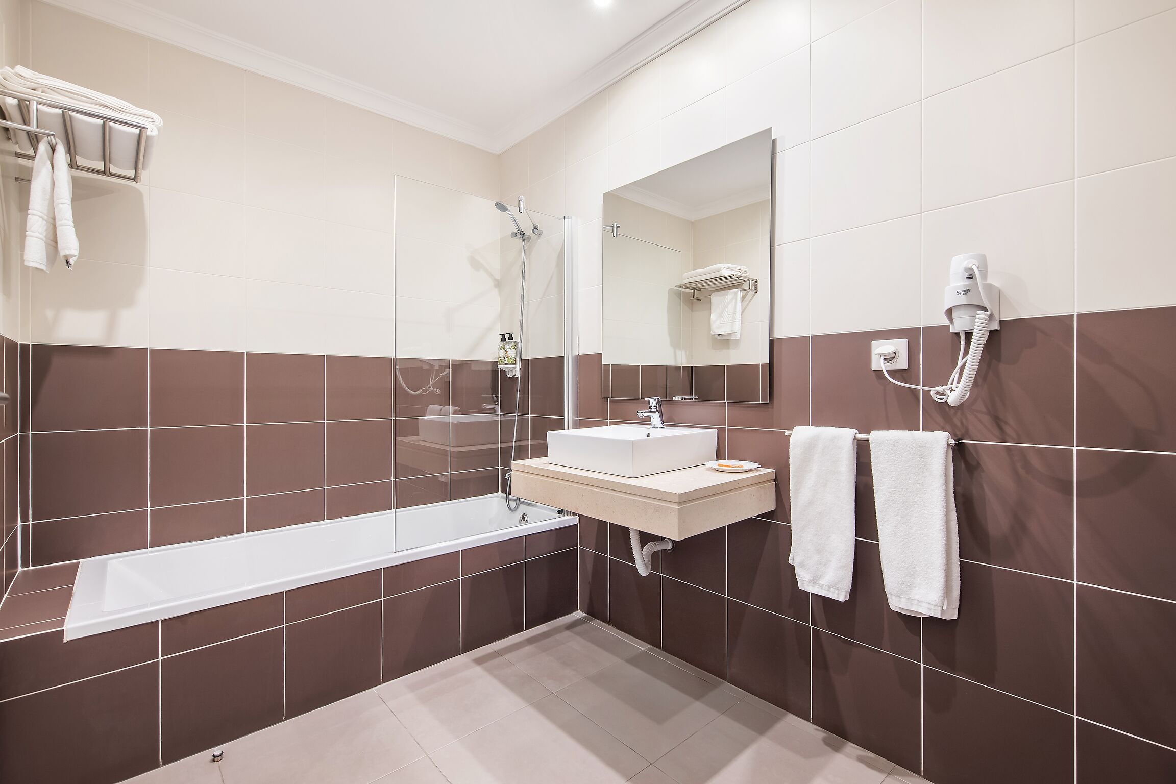 Un baño moderno con una bañera, un lavabo, un espejo y un perchero para toallas.
