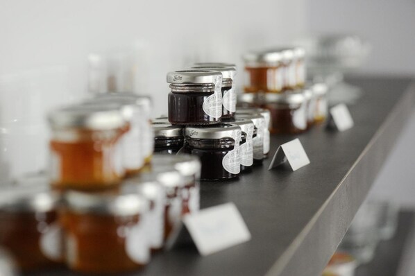 A row of jars with labels on a shelf.