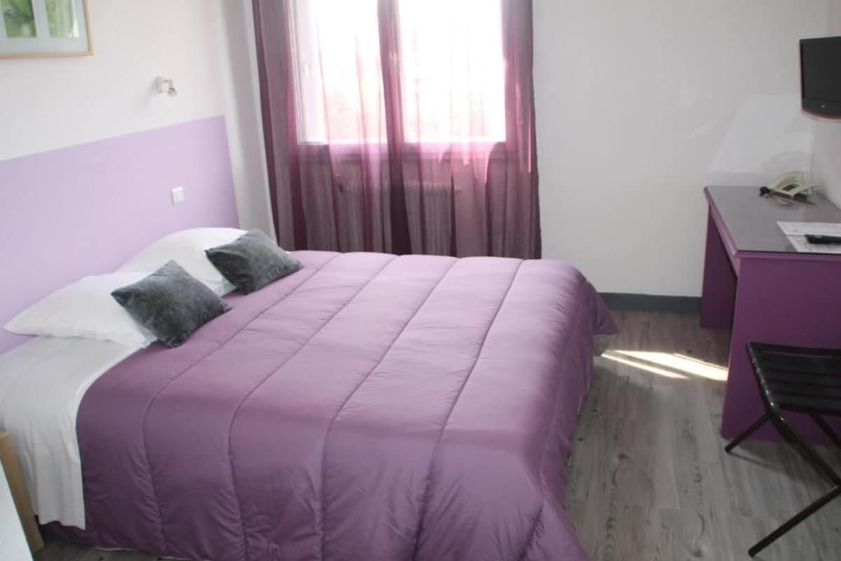 A room with a bed, a desk, and a chair.