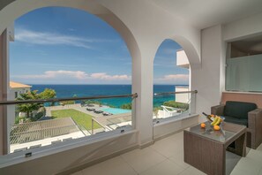 A balcony with a view of the sea, a glass table with fruits, and outdoor furniture. - Kymothoe Elite Suites (Zakynthos)