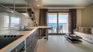 Una cocina moderna con una isla grande, un comedor con vistas y una sala de estar con sofá y mesa de centro.