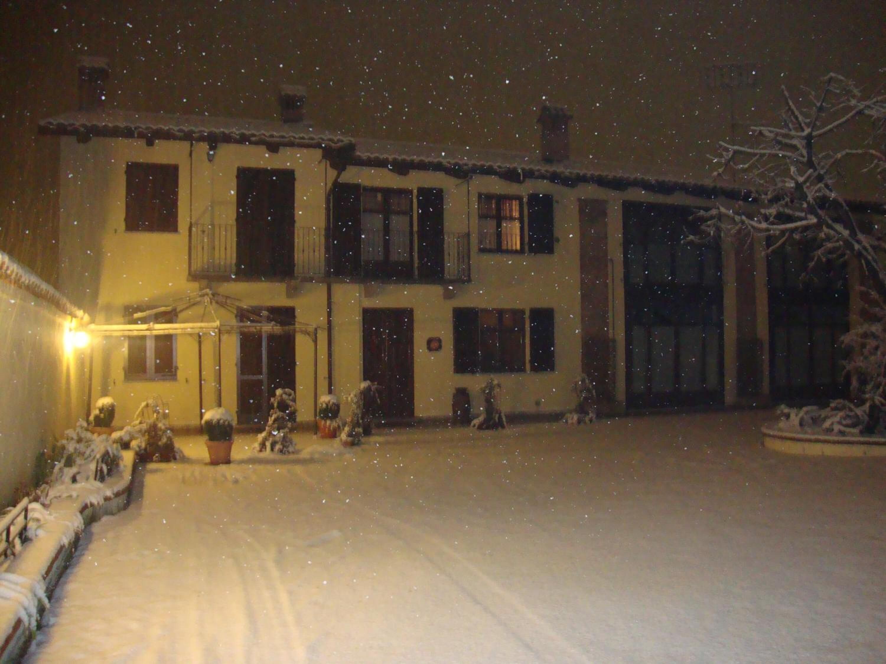Un edificio de dos pisos con numerosas ventanas y balcones, rodeado de nieve.