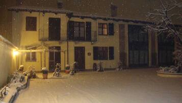 Un edificio de dos pisos con numerosas ventanas y balcones, rodeado de nieve.