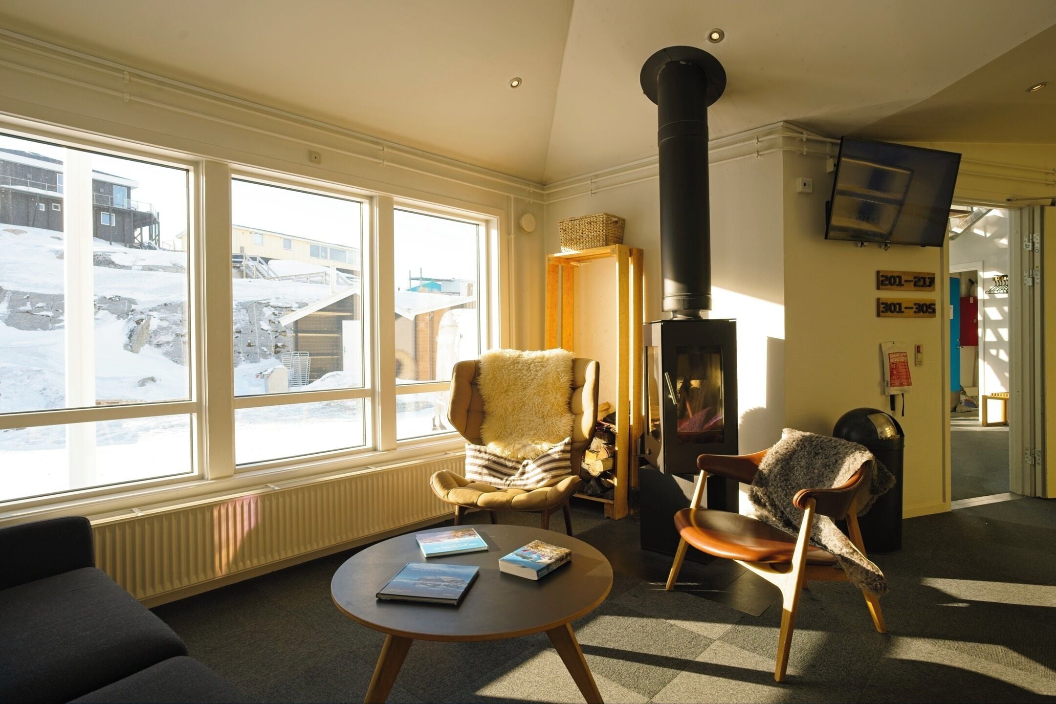 A cozy room with a fireplace, a sofa, a chair, and a table with books.