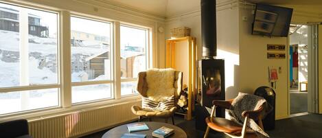 A cozy room with a fireplace, a sofa, a chair, and a table with books.
