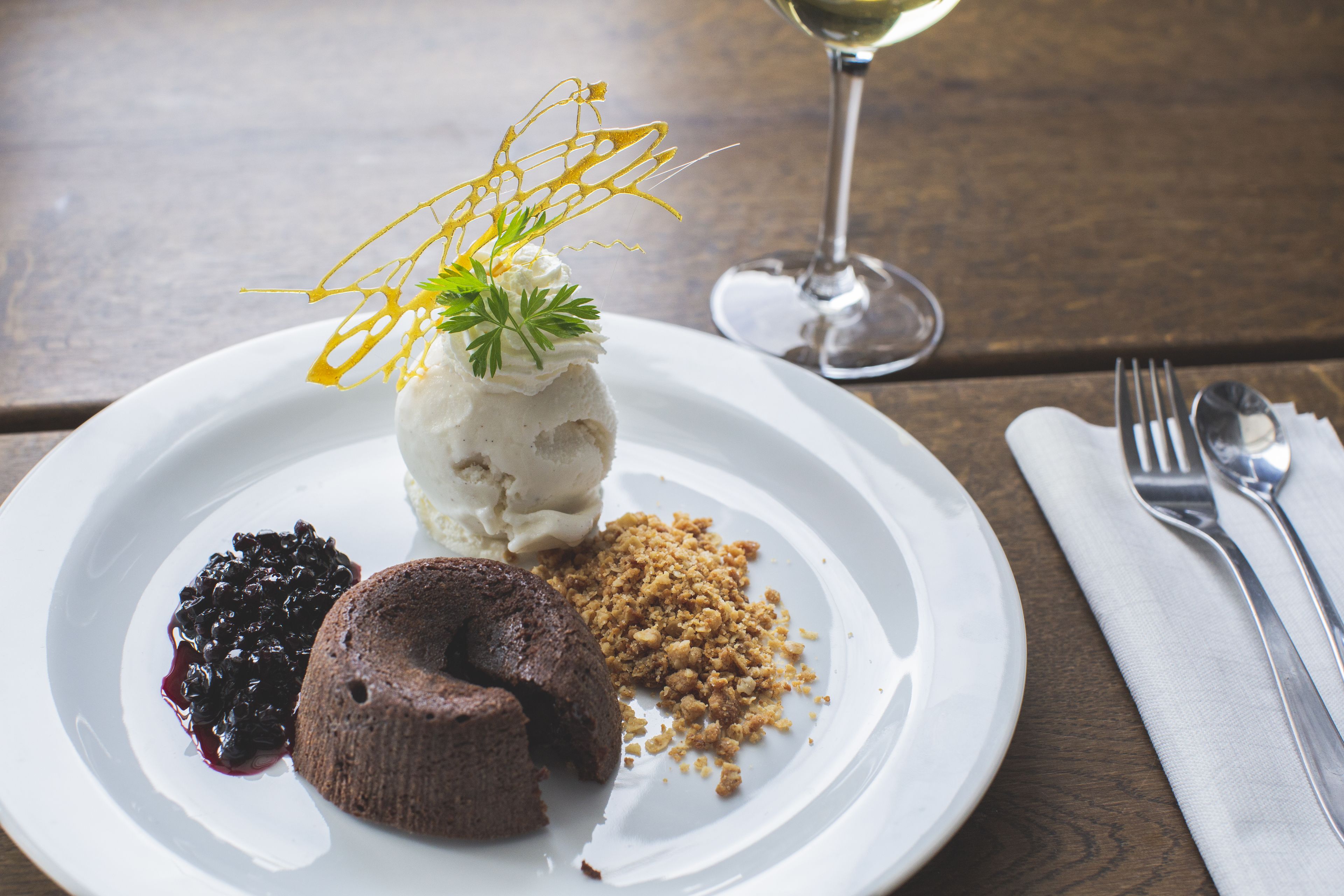A dessert plate with ice cream, a chocolate cake, and a berry compote.