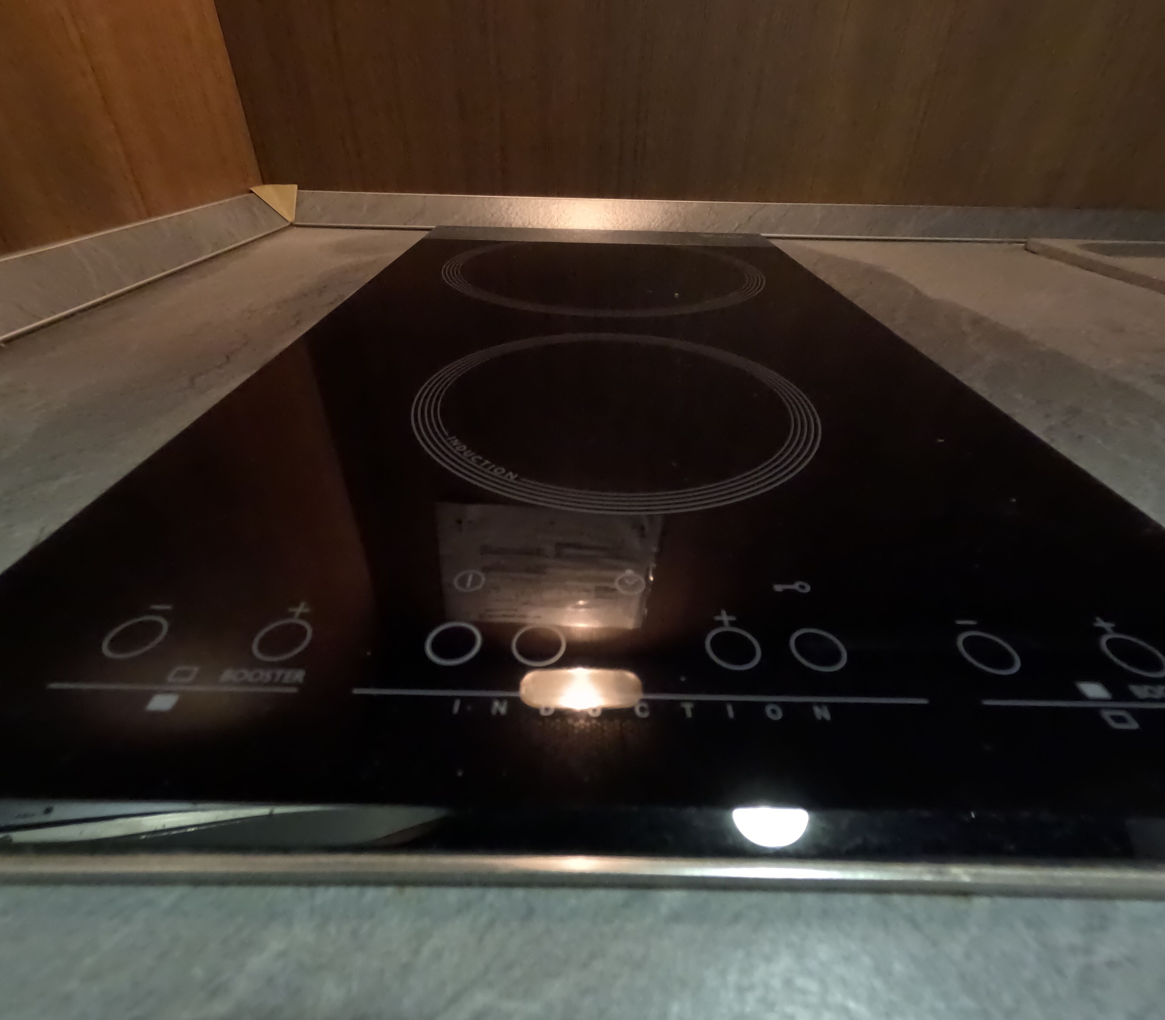 En svart induktionshäll med knappar för styrning och en digital display.