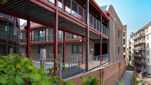 A multi-story building with balconies, a brick facade, and a clear sky. - Residenze Romeo e Giulietta  (Parma)