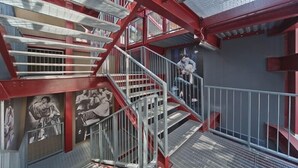 A multi-level metal staircase with railings, surrounded by walls with black and white photographs. - Residenze Romeo e Giulietta  (Parma)