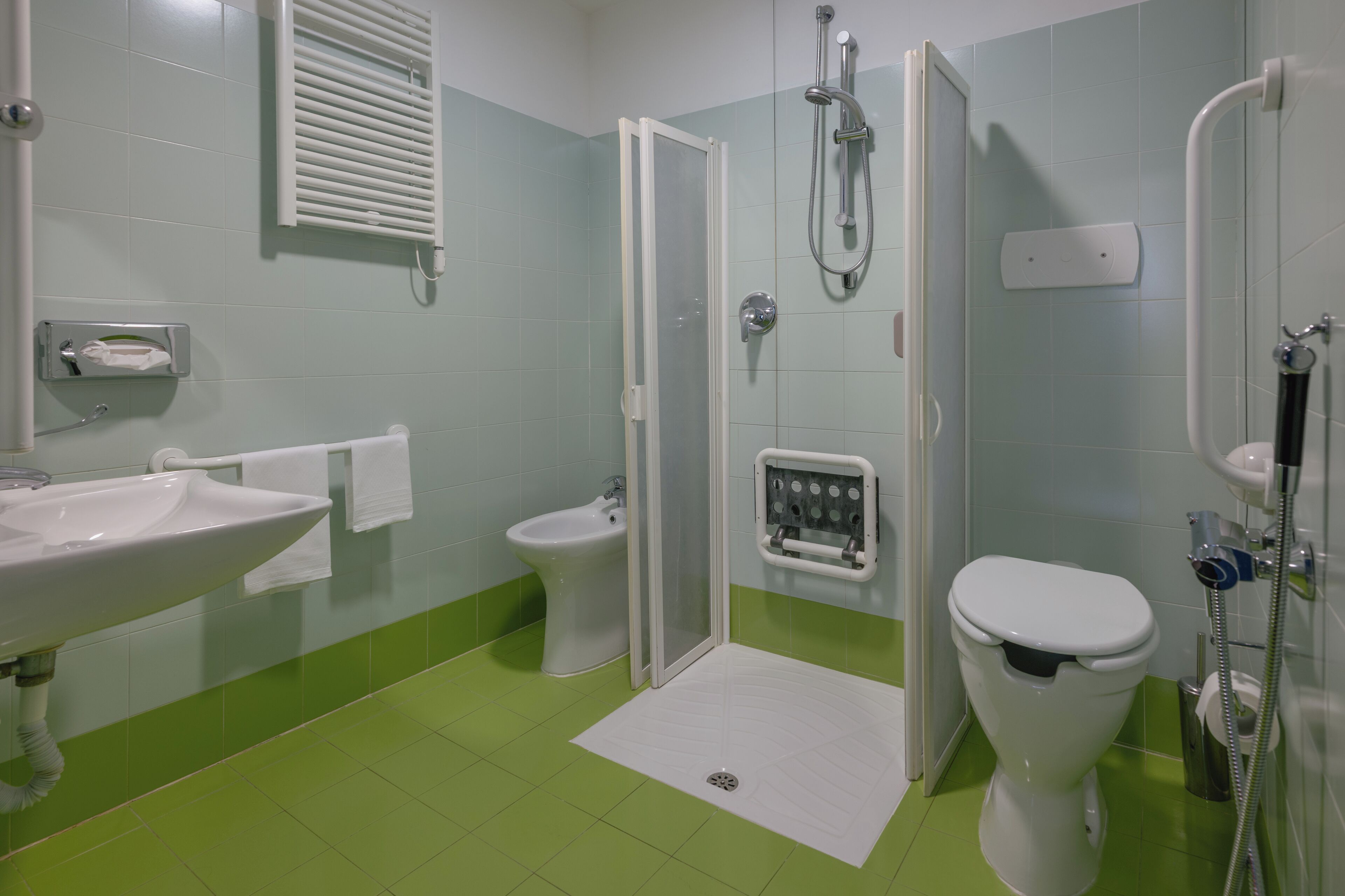 Een badkamer met douche, toilet, bidet en wastafel.