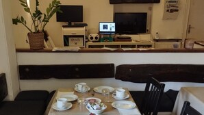 A dining area with a long table set for a meal, including plates, cups, and bowls of food. - Hôtel Restaurant le Palais (Apt)