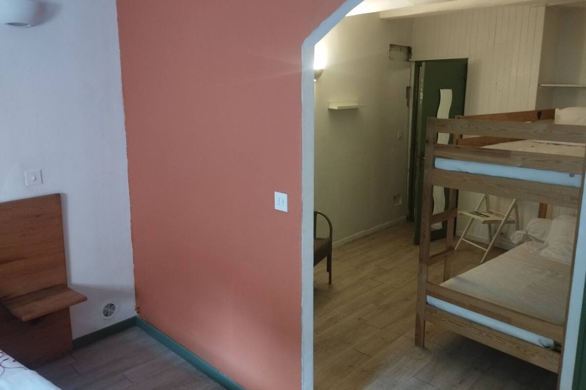 A room with a bunk bed, a chair, and a desk with a chair.