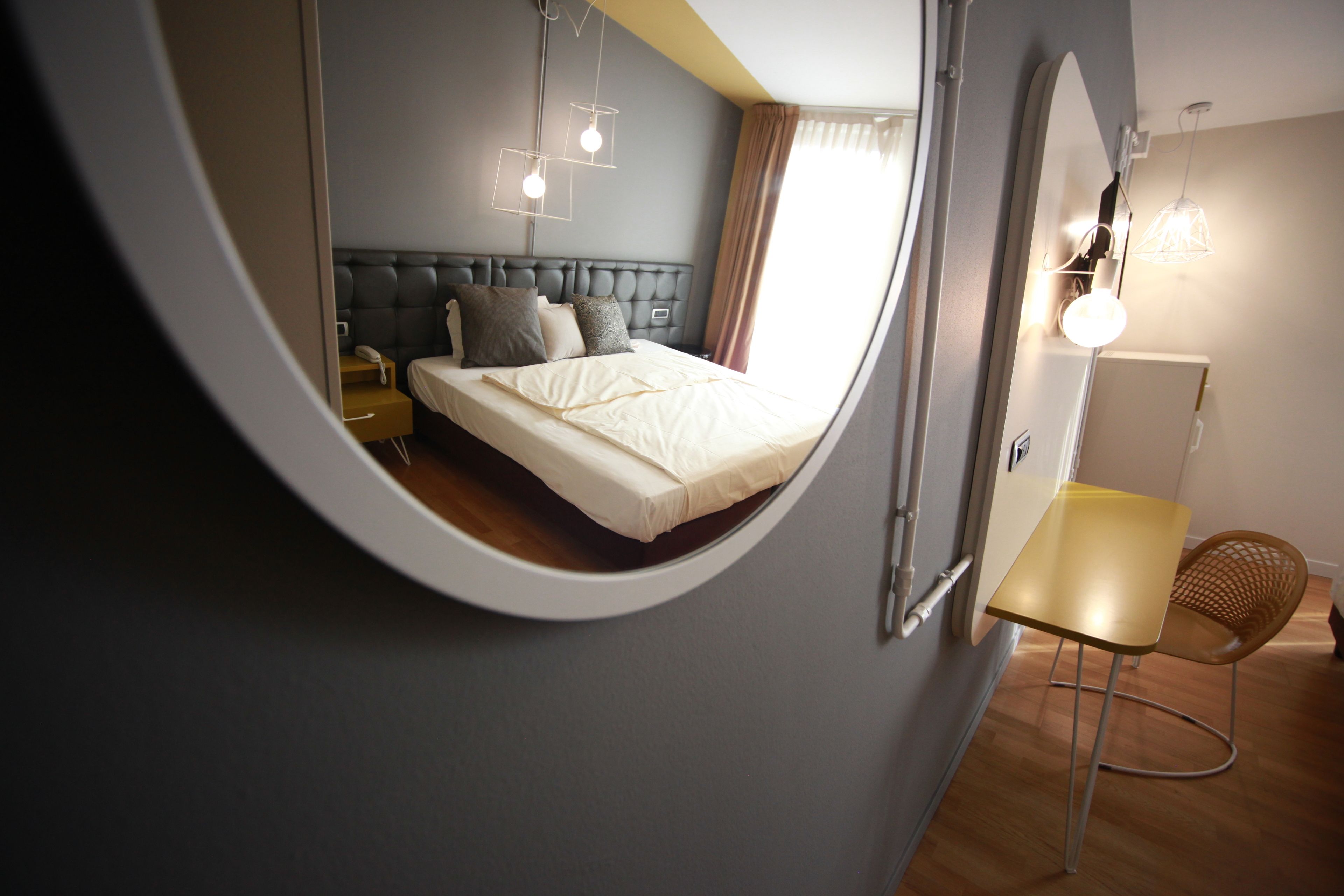 A bedroom with a bed, bedside table, and a chair.