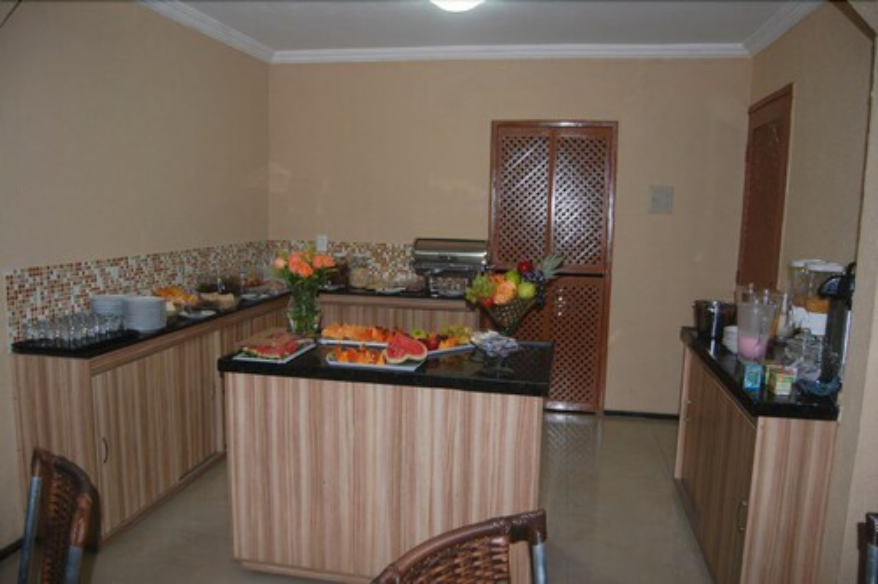 A kitchen with a central island, wooden cabinets, and a tiled backsplash.