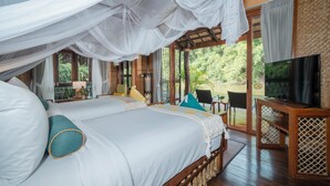 Un dormitorio con una cama grande, televisor y balcón con vistas al exterior.