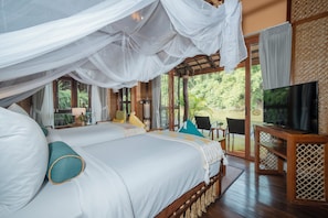 Un dormitorio con una cama grande, televisor y balcón con vistas al exterior.