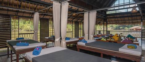 Ein Zimmer mit mehreren Betten, jedes mit Kissen und Decke.