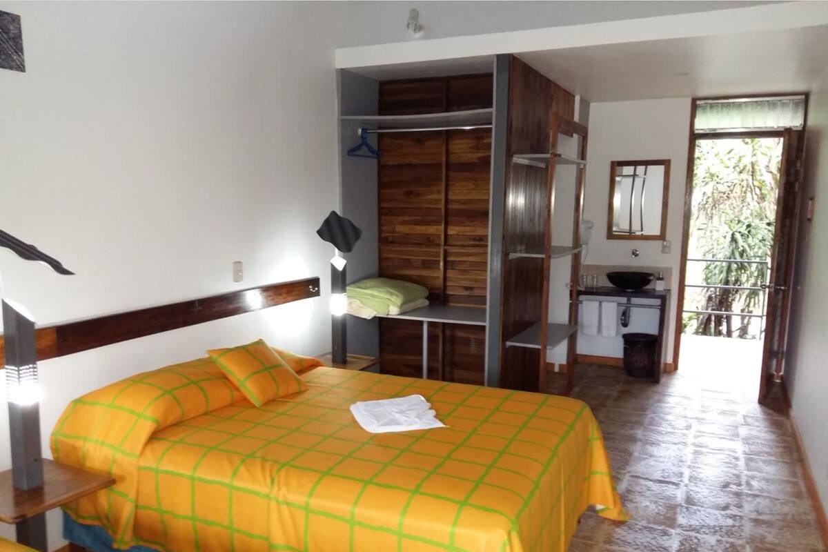 Une chambre à coucher avec un lit, une armoire, une petite table et une fenêtre.