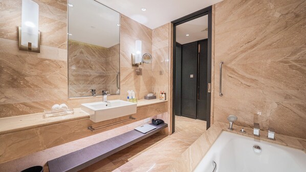 Un baño moderno con un espejo grande, dos lavamanos, una bañera y un mueble de tocador con un perchero.