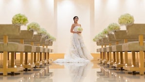 Una ceremonia de boda en una capilla moderna con bancas y arreglos florales.