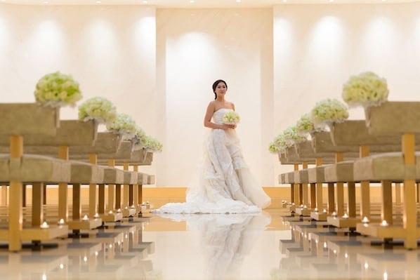 A wedding ceremony in a modern chapel with rows of pews and floral arrangements. - Crowne Plaza Shanghai Anting - 20 Minutes drive to National Exhibition and Convention Center & 15 Minutes drive to F1 (Shanghai)