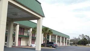A motel with a green roof and multiple balconies. - Western Motel (Folkston)