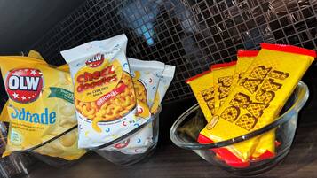 Ett urval av snacksförpackningar, inklusive OLW-snacks och Cheez Doodles, förvarade på ett och samma ställe.