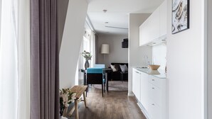 Una cocina moderna con armarios blancos, una mesa de comedor de madera y una silla azul.