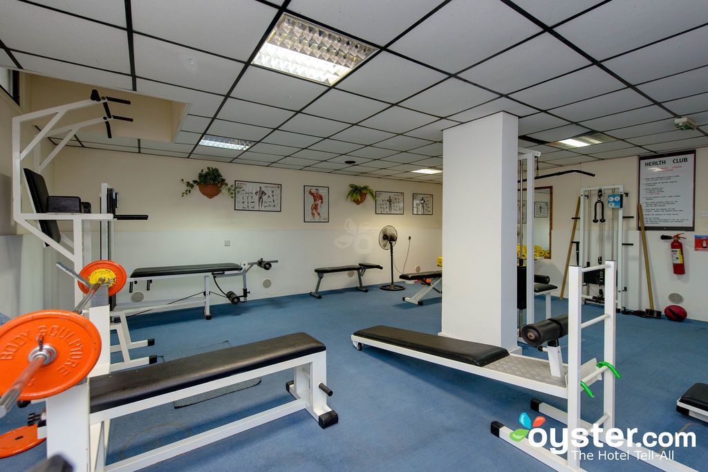 Une salle de sport équipée de matériel de musculation, de bancs et d’appareils d’exercice.